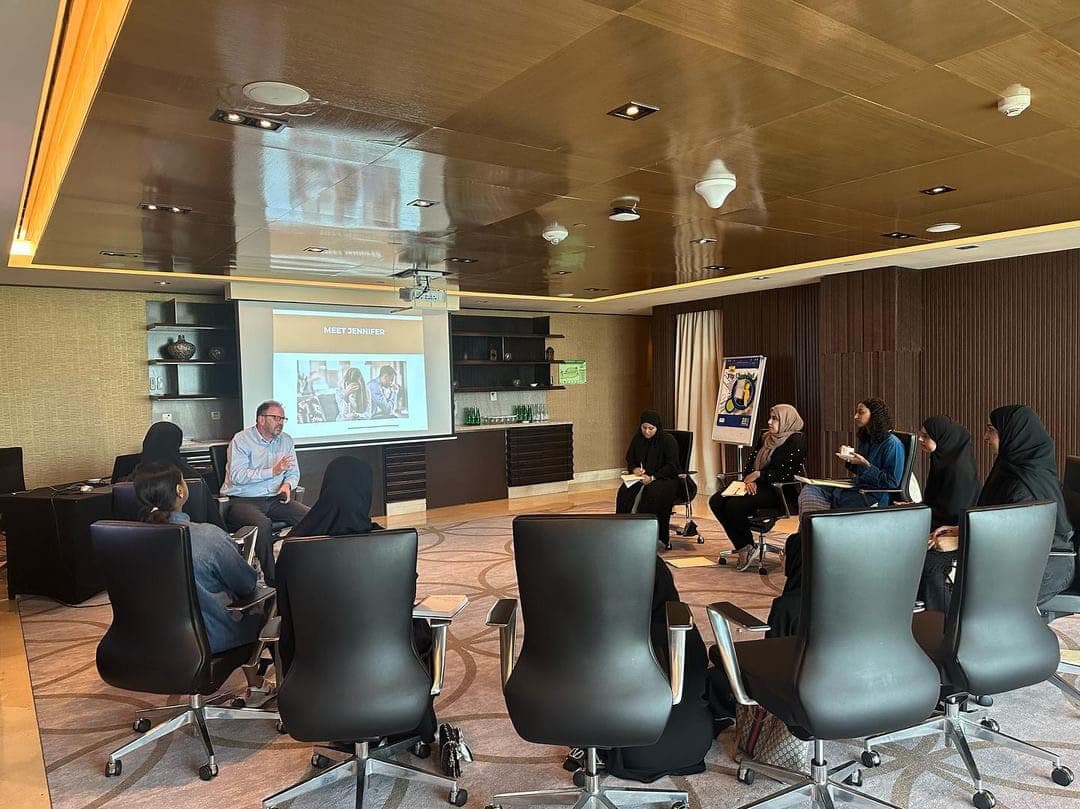 Dr. John Crimmins leading a case study discussion with participants in executive chairs at a premium hotel venue